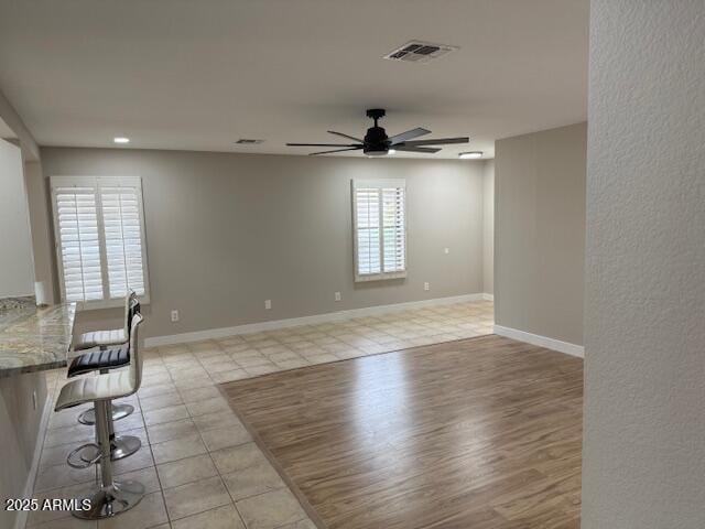 empty room featuring light tile patterned flooring, visible vents, recessed lighting, a ceiling fan, and baseboards