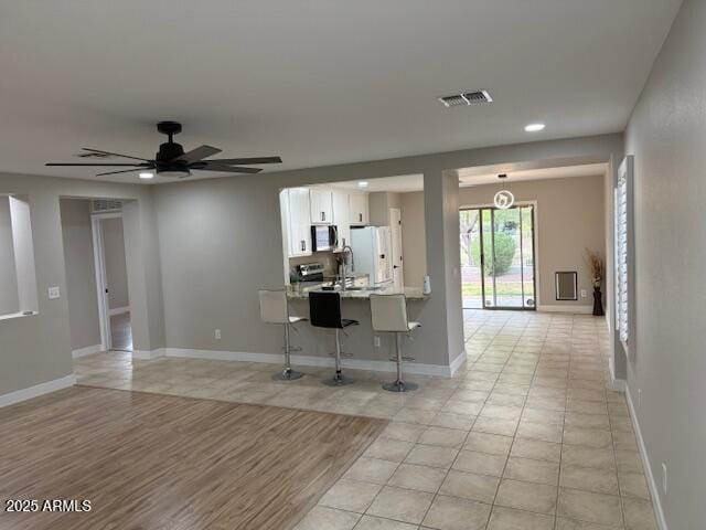 living room with baseboards, ceiling fan, recessed lighting, and light tile patterned flooring