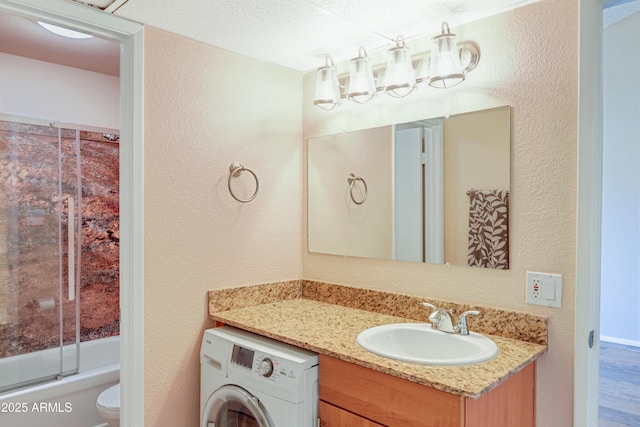 7350 N Via Paseo Del Sur Unit N207, Scottsdale, AZ 85258 - bathroom with washer / dryer, a textured wall, vanity, toilet, and bathtub / shower combination