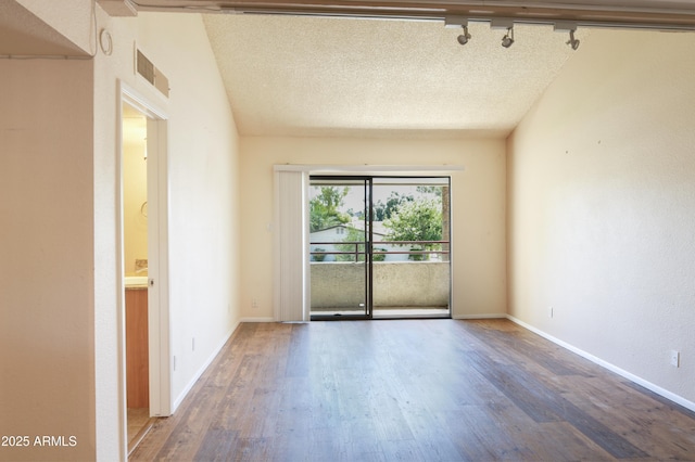 7350 N Via Paseo Del Sur Unit N207, Scottsdale, AZ 85258 - unfurnished room featuring track lighting, wood finished floors, baseboards, and a textured ceiling