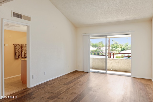7350 N Via Paseo Del Sur Unit N207, Scottsdale, AZ 85258 - spare room with wood finished floors, lofted ceiling, a textured ceiling, and baseboards