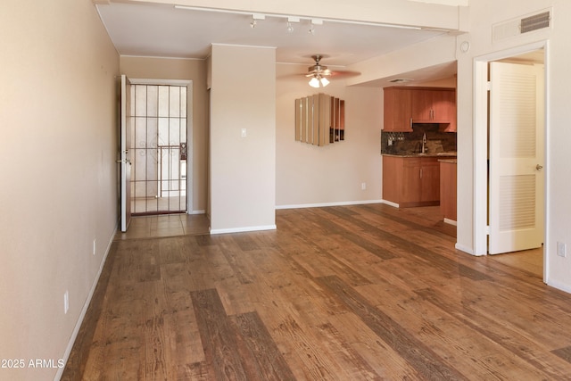 7350 N Via Paseo Del Sur Unit N207, Scottsdale, AZ 85258 - unfurnished living room featuring dark wood-style flooring, ceiling fan, baseboards, and a sink