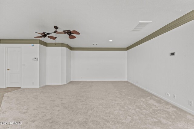 carpeted empty room featuring ceiling fan and crown molding