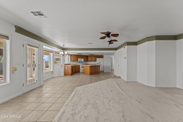 unfurnished living room featuring ceiling fan with notable chandelier, ornamental molding, sink, and light tile patterned floors