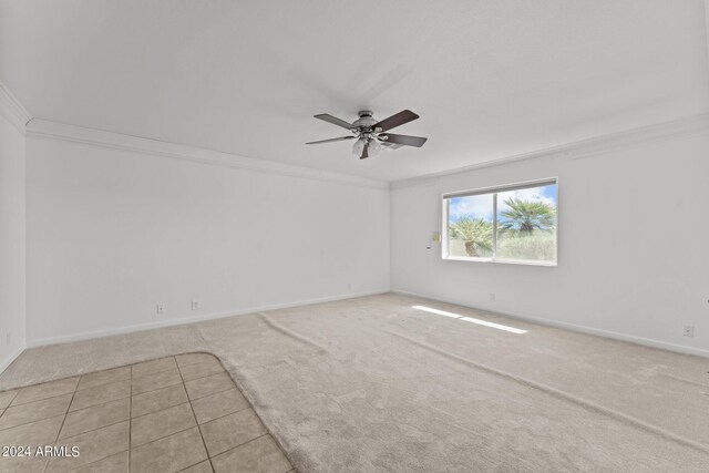 carpeted spare room with ornamental molding and ceiling fan