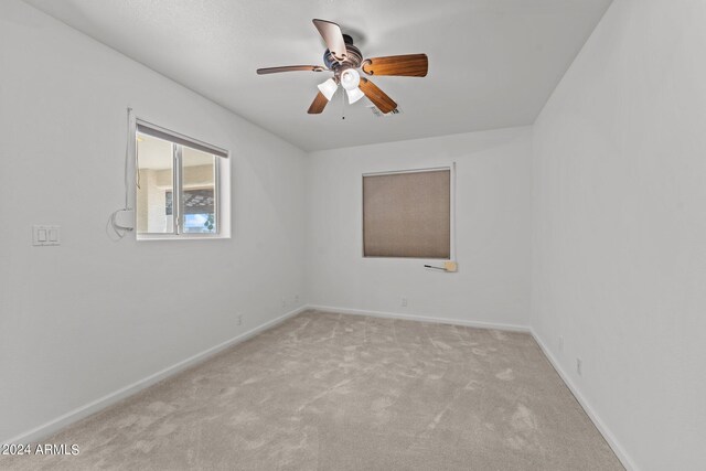 carpeted empty room featuring ceiling fan