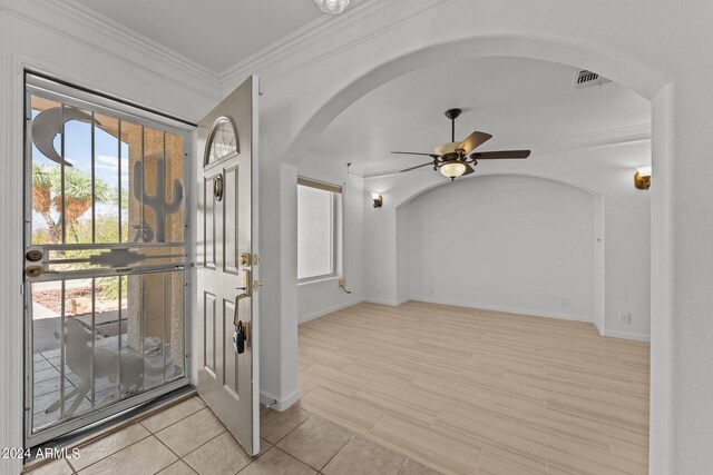 foyer with ceiling fan and crown molding