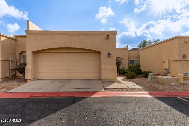 pueblo revival-style home with a garage