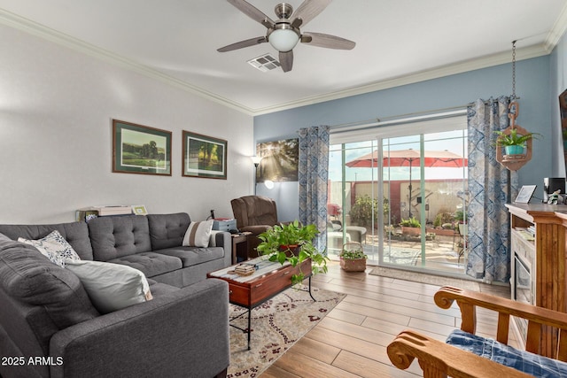 living room featuring crown molding, ceiling fan, a fireplace, and light hardwood / wood-style floors