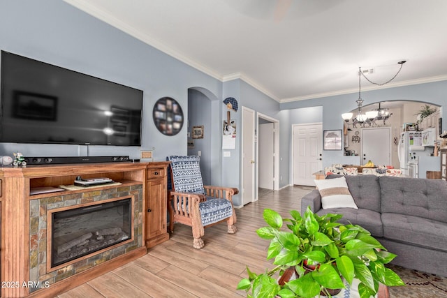 living room featuring an inviting chandelier, ornamental molding, and light hardwood / wood-style floors