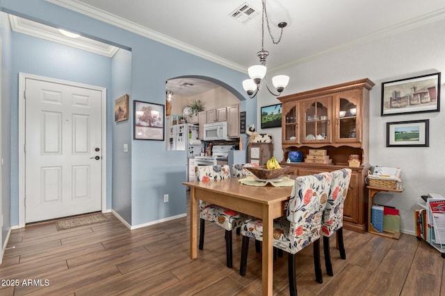 dining area featuring ornamental molding, dark hardwood / wood-style flooring, and a notable chandelier