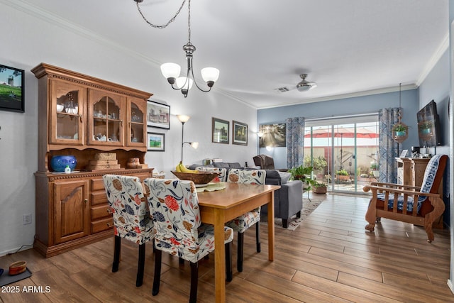 dining room featuring crown molding, ceiling fan with notable chandelier, and light hardwood / wood-style floors