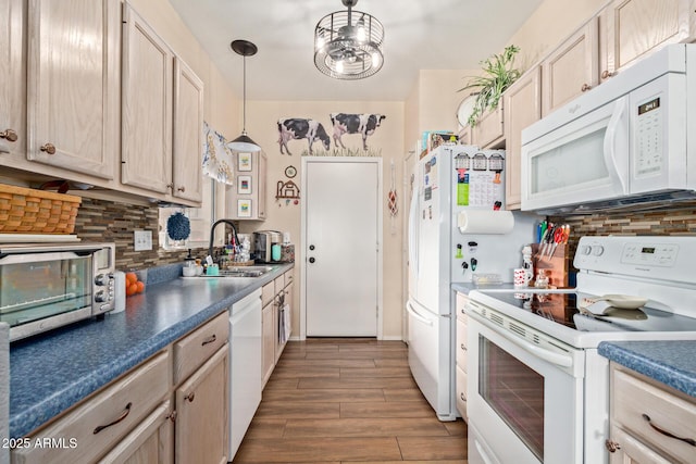 kitchen featuring light brown cabinetry, sink, pendant lighting, white appliances, and decorative backsplash