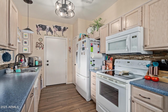 kitchen featuring white appliances, light brown cabinetry, sink, and hanging light fixtures