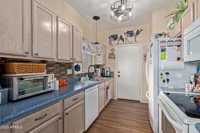 kitchen featuring sink, light brown cabinetry, white appliances, and decorative light fixtures