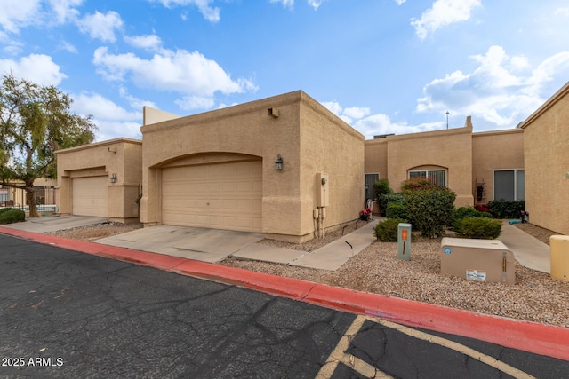 pueblo revival-style home featuring a garage