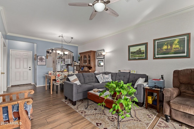 living room featuring hardwood / wood-style floors, ceiling fan with notable chandelier, and ornamental molding