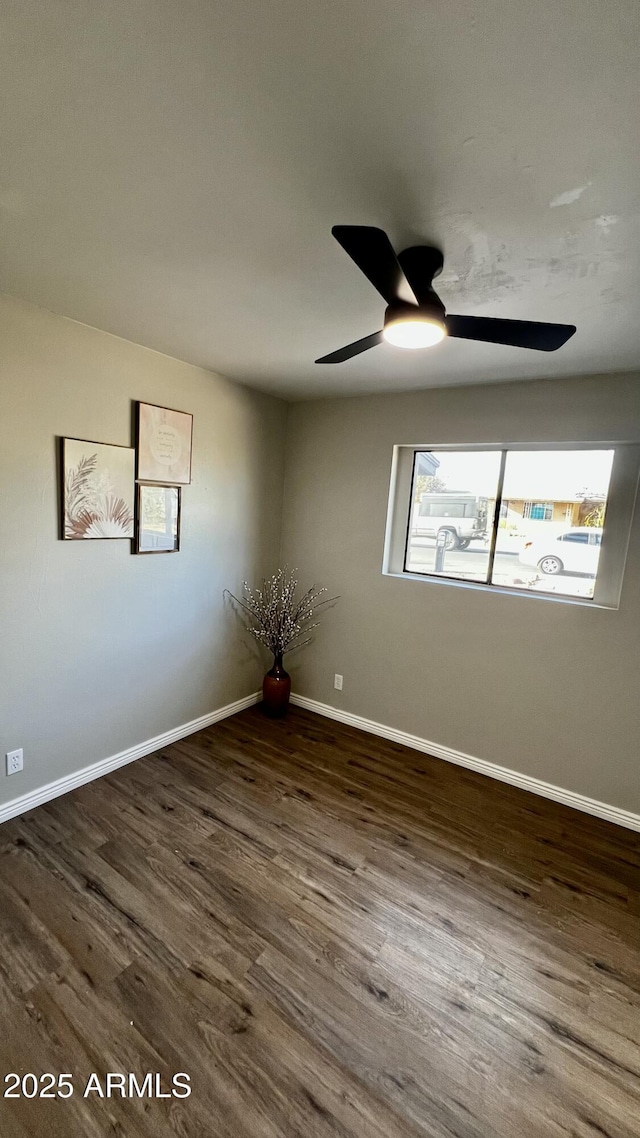 spare room featuring ceiling fan, wood finished floors, and baseboards