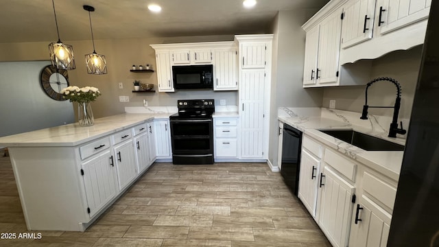 kitchen with a peninsula, black appliances, white cabinets, and a sink