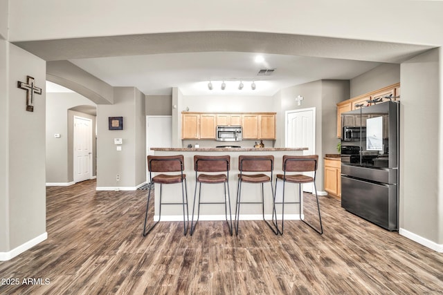 16917 W Sonora St, Goodyear, AZ 85338 - kitchen with appliances with stainless steel finishes, light brown cabinetry, arched walkways, and dark wood-type flooring