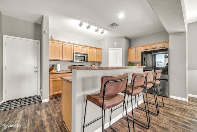 16917 W Sonora St, Goodyear, AZ 85338 - kitchen featuring stainless steel microwave, smart refrigerator, light brown cabinets, dark wood-style flooring, and a breakfast bar area