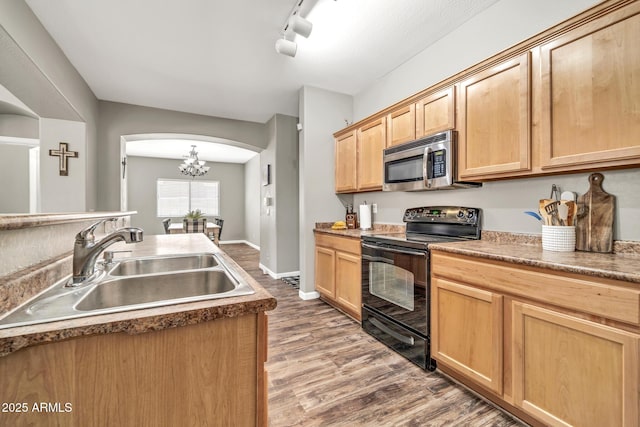 16917 W Sonora St, Goodyear, AZ 85338 - kitchen with stainless steel microwave, black / electric stove, light brown cabinets, wood finished floors, and arched walkways