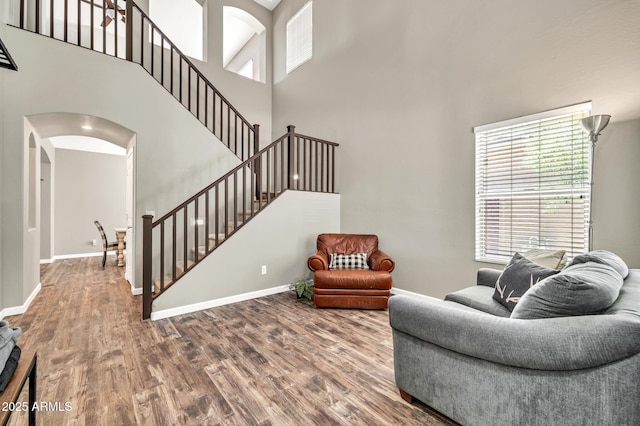 16917 W Sonora St, Goodyear, AZ 85338 - living room with arched walkways, plenty of natural light, wood finished floors, a high ceiling, and stairway