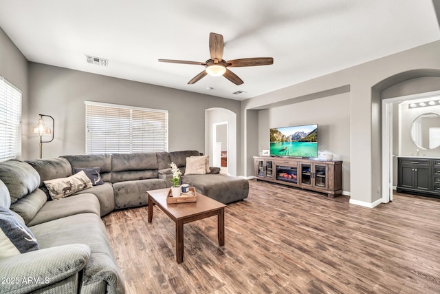 16917 W Sonora St, Goodyear, AZ 85338 - living room with arched walkways, wood finished floors, and ceiling fan