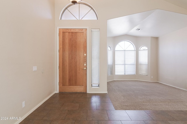 carpeted entrance foyer with vaulted ceiling