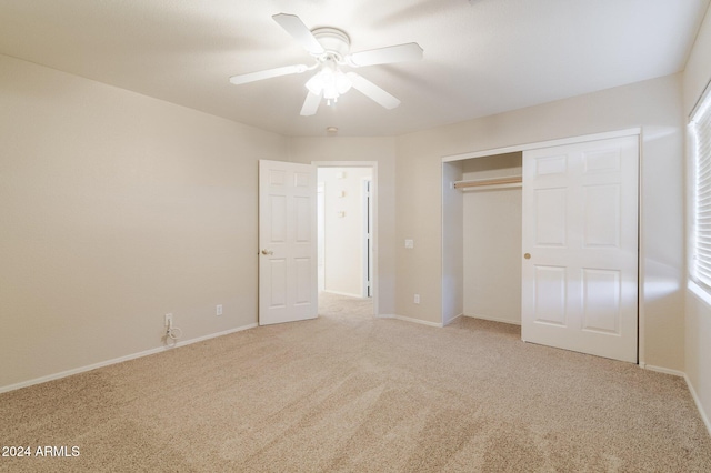 unfurnished bedroom with ceiling fan, light colored carpet, and a closet