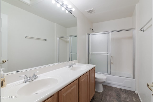 full bathroom with vanity, toilet, and shower / bath combination with glass door