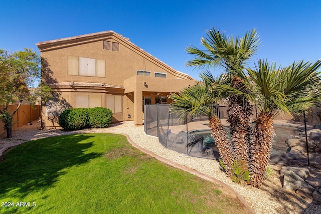 back of property with a patio, a fenced in pool, and a lawn