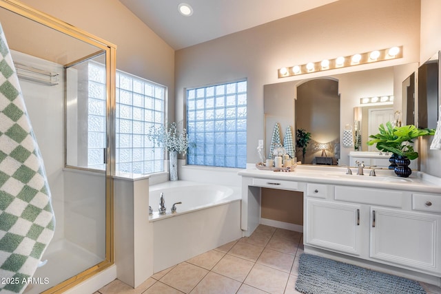 bathroom featuring tile patterned flooring, a garden tub, a shower stall, and vanity