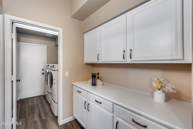 washroom featuring dark wood-style flooring, visible vents, cabinet space, and separate washer and dryer