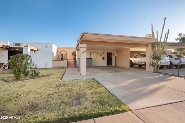 view of front facade with an attached carport, fence, driveway, a gate, and stucco siding