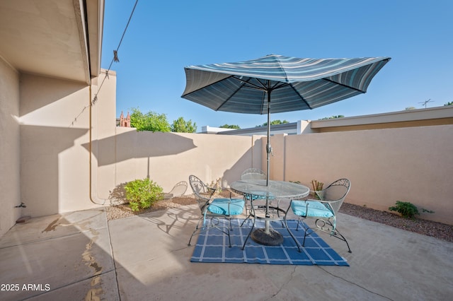 view of patio featuring outdoor dining space and fence