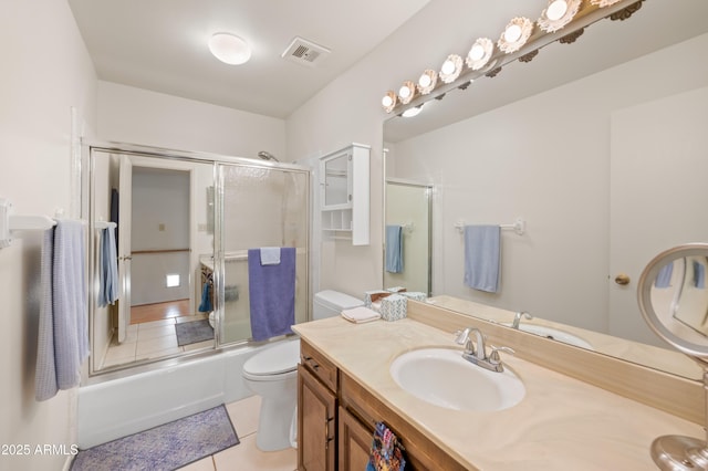 bathroom featuring enclosed tub / shower combo, tile patterned flooring, toilet, vanity, and visible vents