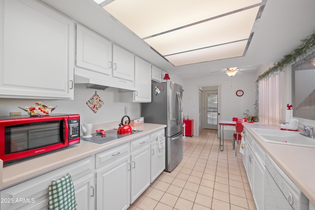 kitchen with white cabinets, electric cooktop, white dishwasher, under cabinet range hood, and a sink