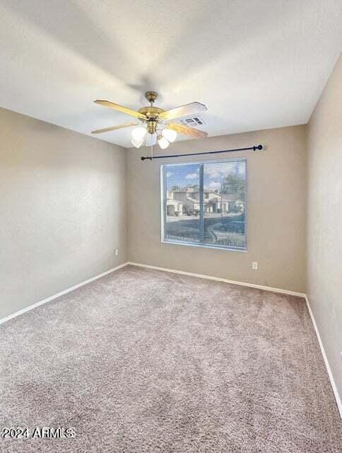 carpeted empty room featuring ceiling fan