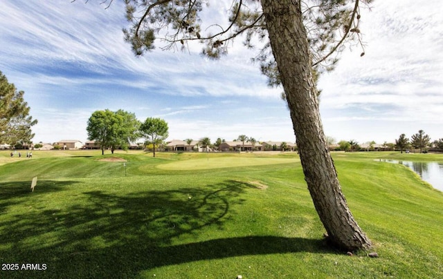 view of property's community with a lawn and a water view