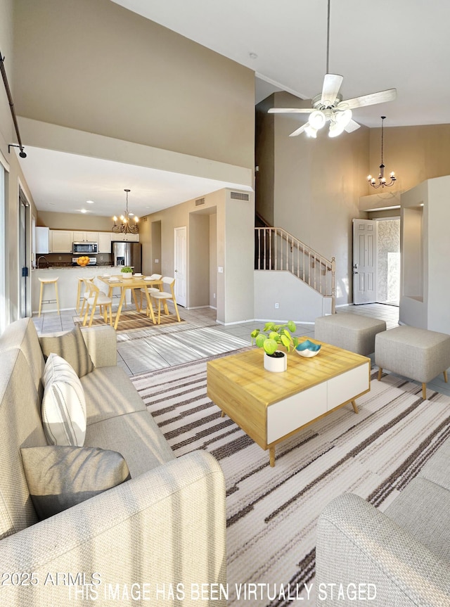 living room featuring ceiling fan with notable chandelier and high vaulted ceiling