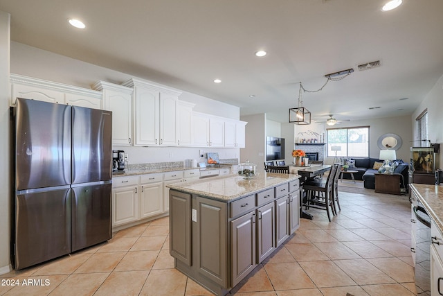 14586 W Columbus Ave, Goodyear, AZ 85395 - kitchen with freestanding refrigerator, open floor plan, white cabinetry, a glass covered fireplace, and recessed lighting