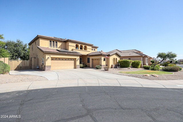 14586 W Columbus Ave, Goodyear, AZ 85395 - mediterranean / spanish home featuring stucco siding, fence, concrete driveway, a garage, and solar panels