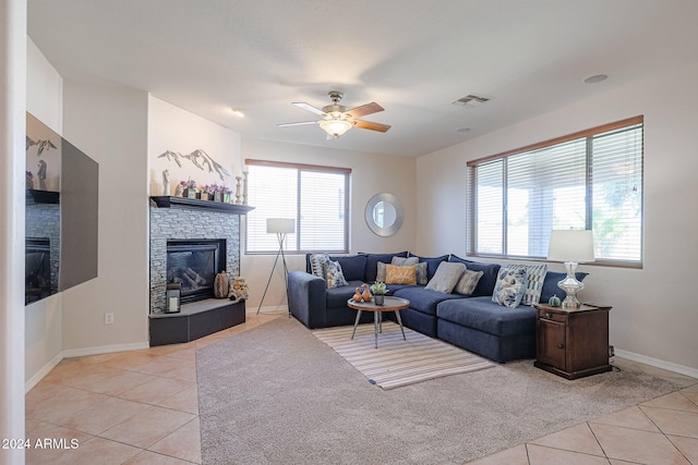 14586 W Columbus Ave, Goodyear, AZ 85395 - living room featuring a stone fireplace, light tile patterned floors, ceiling fan, and baseboards