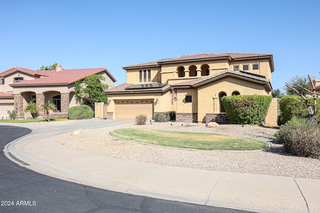 14586 W Columbus Ave, Goodyear, AZ 85395 - mediterranean / spanish house with driveway, stucco siding, an attached garage, stone siding, and a tiled roof