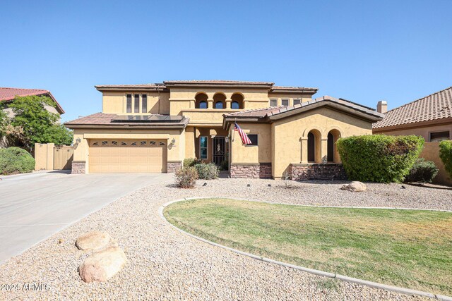 14586 W Columbus Ave, Goodyear, AZ 85395 - mediterranean / spanish-style home featuring stucco siding, concrete driveway, fence, a garage, and stone siding