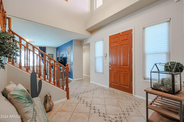 14586 W Columbus Ave, Goodyear, AZ 85395 - foyer entrance with light tile patterned flooring, stairway, baseboards, and healthy amount of natural light