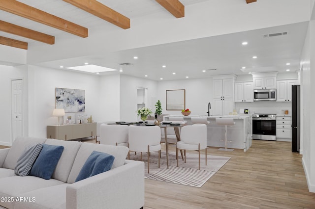 5756 N 78th Pl, Scottsdale, AZ 85250 - living room featuring recessed lighting, light wood finished floors, beam ceiling, and baseboards