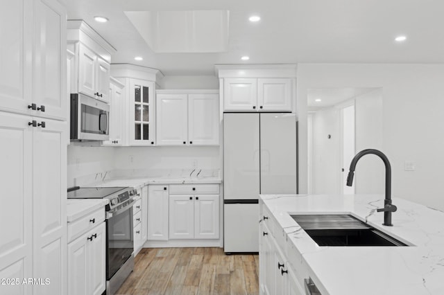 5756 N 78th Pl, Scottsdale, AZ 85250 - kitchen featuring stainless steel appliances, a sink, light wood finished floors, recessed lighting, and white cabinetry