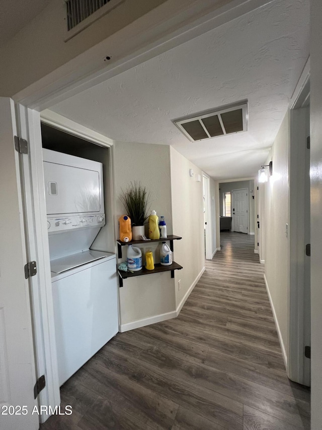 4040 N Weimer Pl Unit 4, Tucson, AZ 85719 - hallway featuring stacked washing maching and dryer, baseboards, visible vents, and wood finished floors